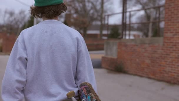 Nastoletni Chłopiec Deskorolką Odchodzi Kierunku Tylnej Alejki Parkingu — Wideo stockowe