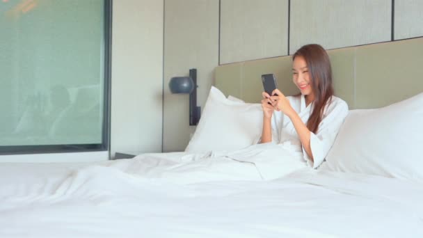 Happy Asian Woman Reading Messages Smartphone Waking Bed Morning Routine — Stock Video