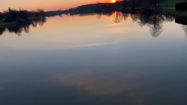 ドイツの水に夕日の空の反射を持つプリーストリー湖 チルトアップショット — ストック動画