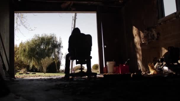 坐在黑暗肮脏的车库里的一个孤独 悲伤的少年的人物形象的手持照片 慢动作拍摄 每秒钟60帧 — 图库视频影像
