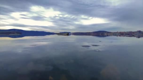 遠くの山々と雲の上に遠くの都市と広大な川を明らかにするために水の下のカメラ 夢のような一日 — ストック動画