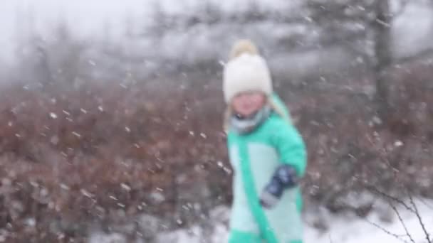 Liten Flicka Kör Snöstorm Fokus Från Snö Till Flicka Slomo — Stockvideo