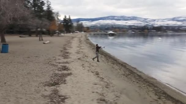 Letecký Pohled Mladý Rybář Rybářskou Prutem Lakeside Snow Capped Hills — Stock video