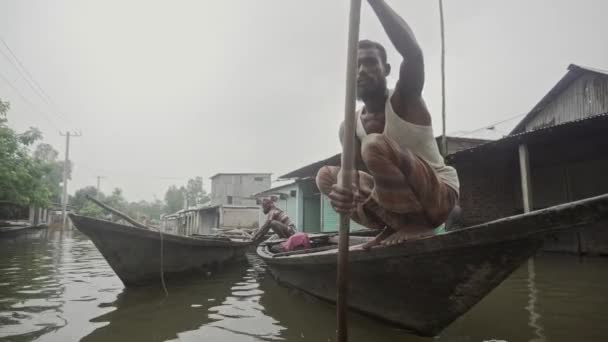 北バングラデシュの浸水した家を持つ船頭のオアリングボート — ストック動画