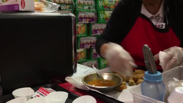 销售人员向Costco商店内具有4K解像度的顾客提供春卷食品样品 — 图库视频影像