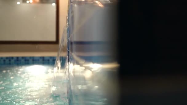 Close Up View Of Water Flowing From Jacuzzi Into Pool. Slow Motion, Follow Shot