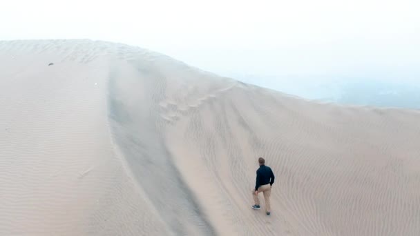 砂丘を登る男だ ハカチーナペルー砂漠無人航空機 — ストック動画