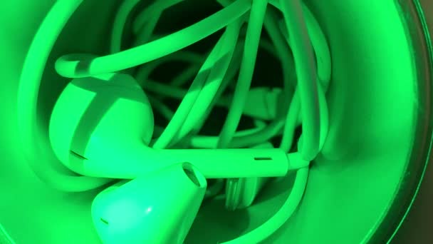 緑の光に絡まったイヤフォン — ストック動画