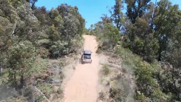 4Wdの空中ドローンショット未舗装道路を運転するビクトリア州アイルドン湖の近くの青い水と山を見るために新興オーストラリア — ストック動画