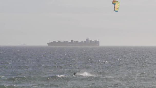 Kitesurfer Átvágja Hullámzó Vizeket Háttérben Áthaladó Teherhajó — Stock videók