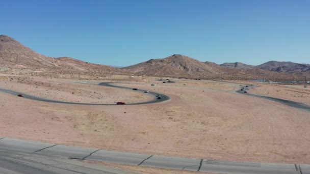モハーヴェ砂漠の風景を背景にしたレーストラックでのチャンピオンシップのための車のレース — ストック動画
