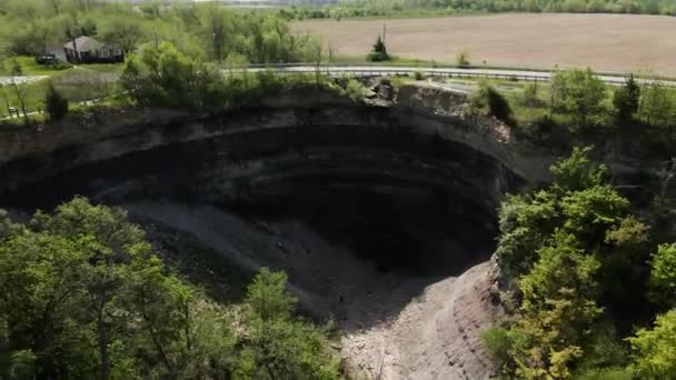 カナダの夏の間 農場に囲まれた有名な悪魔のパンチボウルの空中逆撮影 — ストック動画