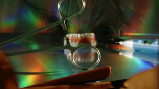 牙齿模型 带彩虹色的夹钳和孔雀羽毛滑入 — 图库视频影像