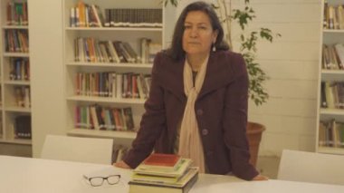 Üniversitede profesyonel bayan öğretmen kameraya bakıyor, 4K görüntüsünü kapatın.