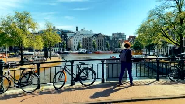 Turist Kvinna Tittar Till Kanalen Amsterdam Från Bro Med Cyklar — Stockvideo