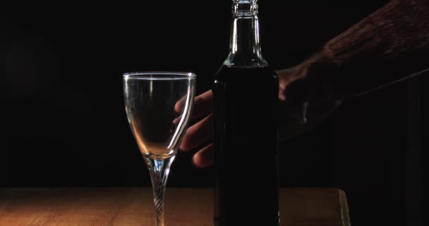 Pouring wine into a crystal glass in a cellar in soft light, close up
