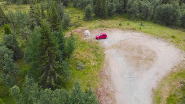 Red Car And A Tent In A Camping Ground With Vegetation In Sweden. aerial drone