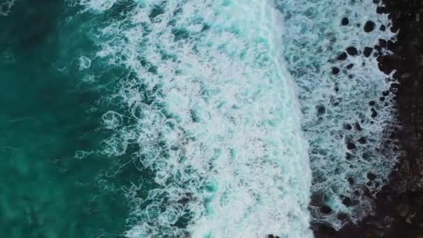 バリ島の観光スポットの1つであるヌサペニダ島の海岸線をクラッシュさせるターコイズブルーの海の波の空中ショット壊れたビーチの横にあるビラボンビーチの角度をキーイングするクリスタルビーチ 空中風景 — ストック動画