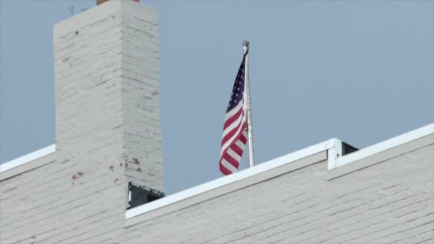 建筑物顶部的美国国旗在风中飘扬 慢动作 — 图库视频影像