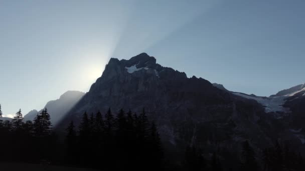 太阳缓缓地从山后升起 后面闪烁着美丽的光芒 在瑞士的Ccablecar Nier Grindelwald向左缓慢移动 — 图库视频影像