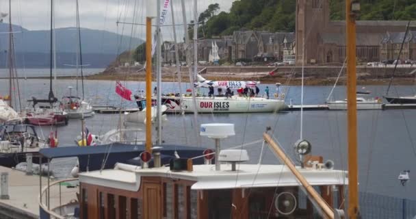 人々はスコットランドのオバンのマリーナでドッキングした私たちの島と海のボートに乗っています ズームアウト — ストック動画
