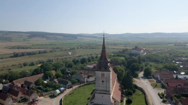 Aerial of a beautiful, old church tower. Drone flying backwards and revealing beautiful Romanian town