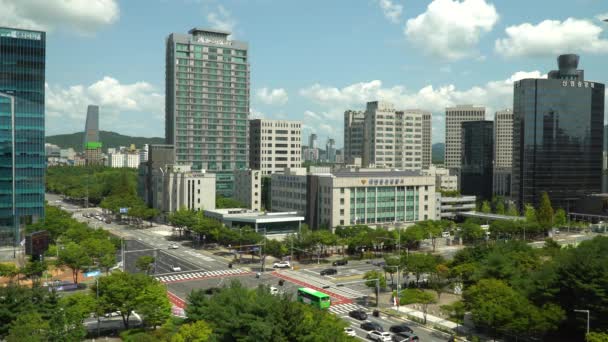 高層ビルや高層ビルを通り過ぎる大田市交通韓国の昼間に警察署ビル ワイドショット — ストック動画
