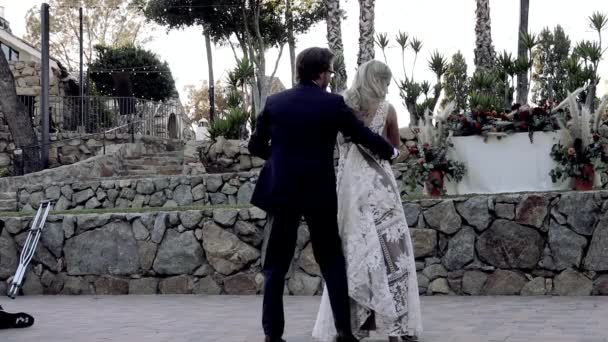 A bride in a retro lace dress spins into the arms of the groom at their first dance. Slow motion video