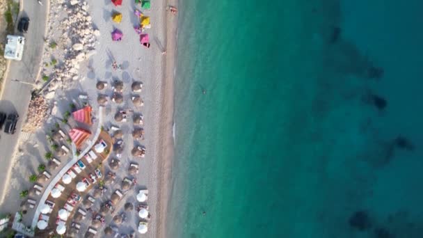 Ruhiger Strand Mit Bunten Sonnenschirmen Gewaschen Von Klarem Türkisfarbenem Meerwasser — Stockvideo