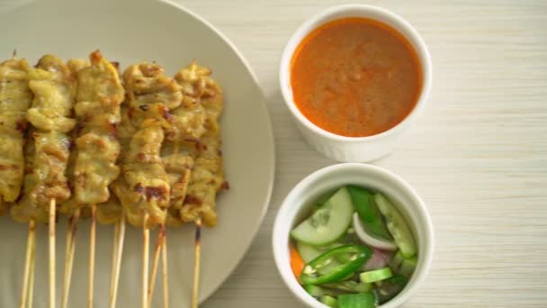 酢でキュウリのスライスと玉ねぎであるピーナッツソース漬物とポークサテ アジア料理スタイル — ストック動画