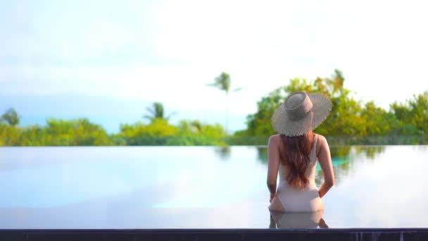 Vista Posteriore Della Donna Seduta Sul Bordo Della Piscina Sfioro — Video Stock