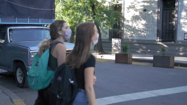 Mladí dospělí v maskách kráčejících přes ulici jako starý náklaďák čeká na světle
