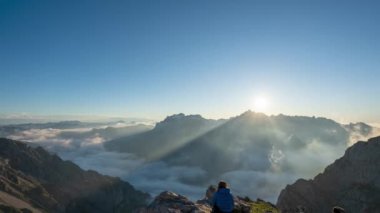 Yürüyüşçü İspanya, Leon 'da Picos de Europa' daki Collado Jermoso Barınağı 'nda Düşük Bulutlu Görkemli Günbatımını izliyor. Geniş açı, zaman ayarlı