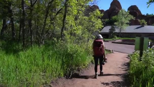 美国科罗拉多州罗克斯伯勒州立公园 阳光明媚的夏日 背负盈亏 步履维艰的女性风景摄影师 — 图库视频影像