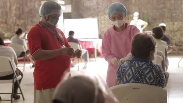 菲律宾Bacolod市 一名身穿Ppe的护士向一名老年妇女注射Covid 19疫苗 这名老年妇女有一名男性志愿者 在疫苗接种期间注射了一个石膏 — 图库视频影像