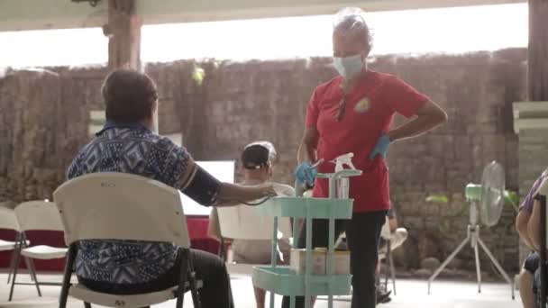 女性ボランティアフィリピンのバコロッド市での予防接種後の高齢者へのインタビュー スタティックショット — ストック動画