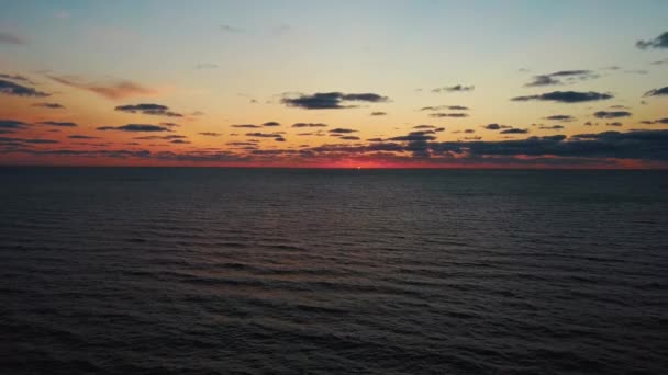 Dron přeletěl nad mořem v krásném západu slunce. Letecký Drone Shoot. Východ slunce nad mořem. Barevný západ slunce v Baltském moři, Lotyšsko. Kamera se pohybuje pozpátku