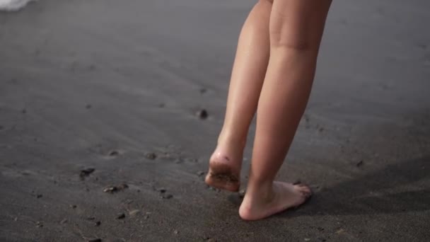 Mädchen Läuft Über Schwarzen Vulkanstrand Mit Kleinen Wellen Auf Fuerteventura — Stockvideo