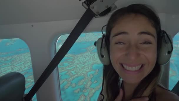 Eine Reisende genießt im Flugzeug die Luftaufnahmen der Whitsunday Islands in Australien durch ein Glasfenster. Nahaufnahme