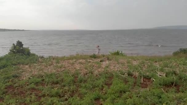 アフリカの田舎のビクトリア湖を見てサファリスーツを着た男 — ストック動画