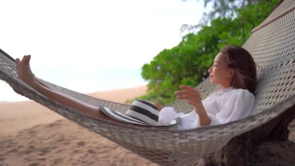 Mulher Asiática Balançando Rede Enquanto Enfrenta Mar Calmo Menina Despreocupada — Vídeo de Stock