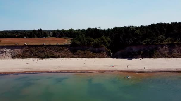 飞越海岸线波罗的海Jurkalne海滨悬崖靠近Pavilosta Latvia和山体滑坡与一片茂密的裂谷 碎石和卵石 空中无人机视图 相机移动Sideware — 图库视频影像