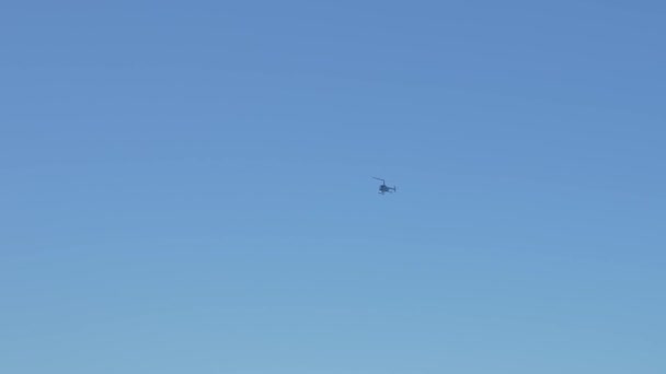 Ελικόπτερο Που Πετά Ενάντια Στον Καθαρό Μπλε Ουρανό Πάνω Από — Αρχείο Βίντεο