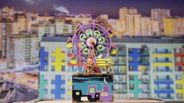 DIY Wooden Music Box s ruční klikou Ferris kolo na vrcholu, rotující proti barevné miniaturní město koncepce pozadí. Přiblížení