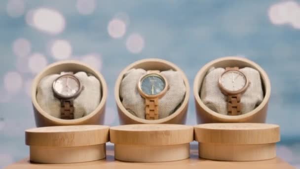 輝く背景に丸い竹の箱を持つ女性のための木製時計の製品バリアント プロダクト広告の概念 ズームアウト — ストック動画