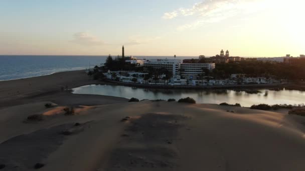 スペインのグラン カナリア島マスパロマス近くの海沿いの街の素晴らしい低高度ドローンビュー マスパロマス島に沈む太陽 — ストック動画