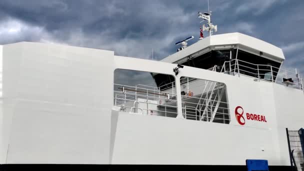 ボレル社のフェリーKinsarvikがゆっくりとKinsarvik Norwayの港に到着 会社のロゴが表示された船側とホイールハウスの静的クローズアップ 背後に暗いムーディーな雲 — ストック動画