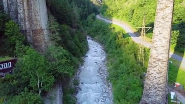 位于瑞士卢加诺的山桥越过落基溪流 经过山脚上的房子 空中后撤 — 图库视频影像