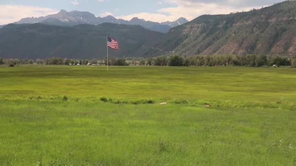 Gran Bandera Americana Ondeando Viento Sobre Prado Con Las Montañas — Vídeos de Stock