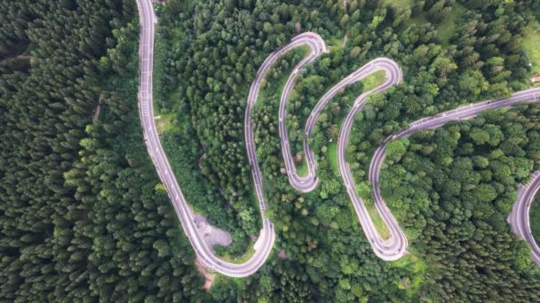 ルーマニアのブステニにある風光明媚な山の風の強い高速道路の空中トップダウンビュー ルーマニアの緑豊かな木々に囲まれた曲がりくねった山道の美しい空の景色 — ストック動画